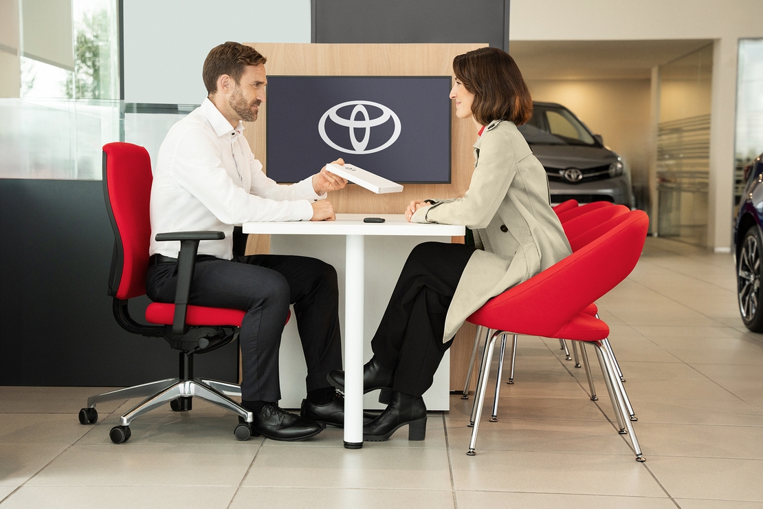 Toyota-exterieur-vrouw-aan-tafel-bij-dealer-met-contract